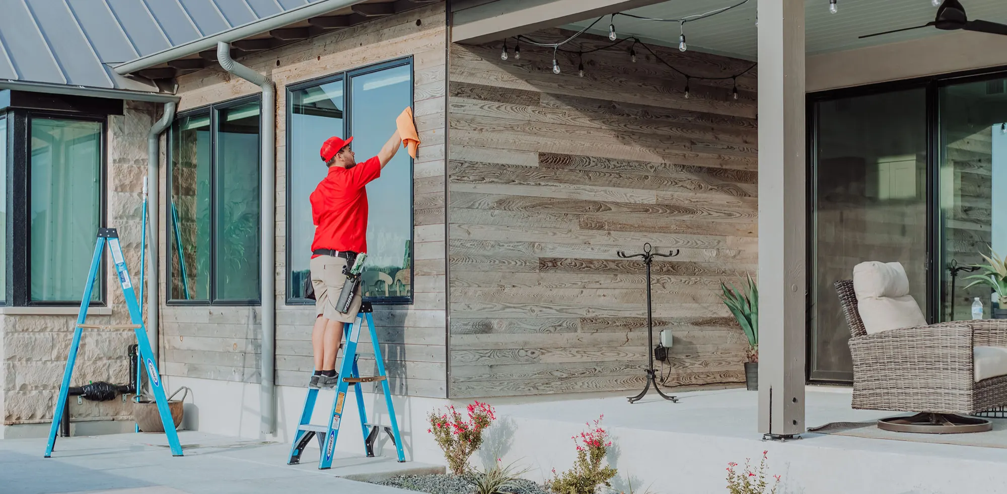 Shine technician cleaning the windows of a patio