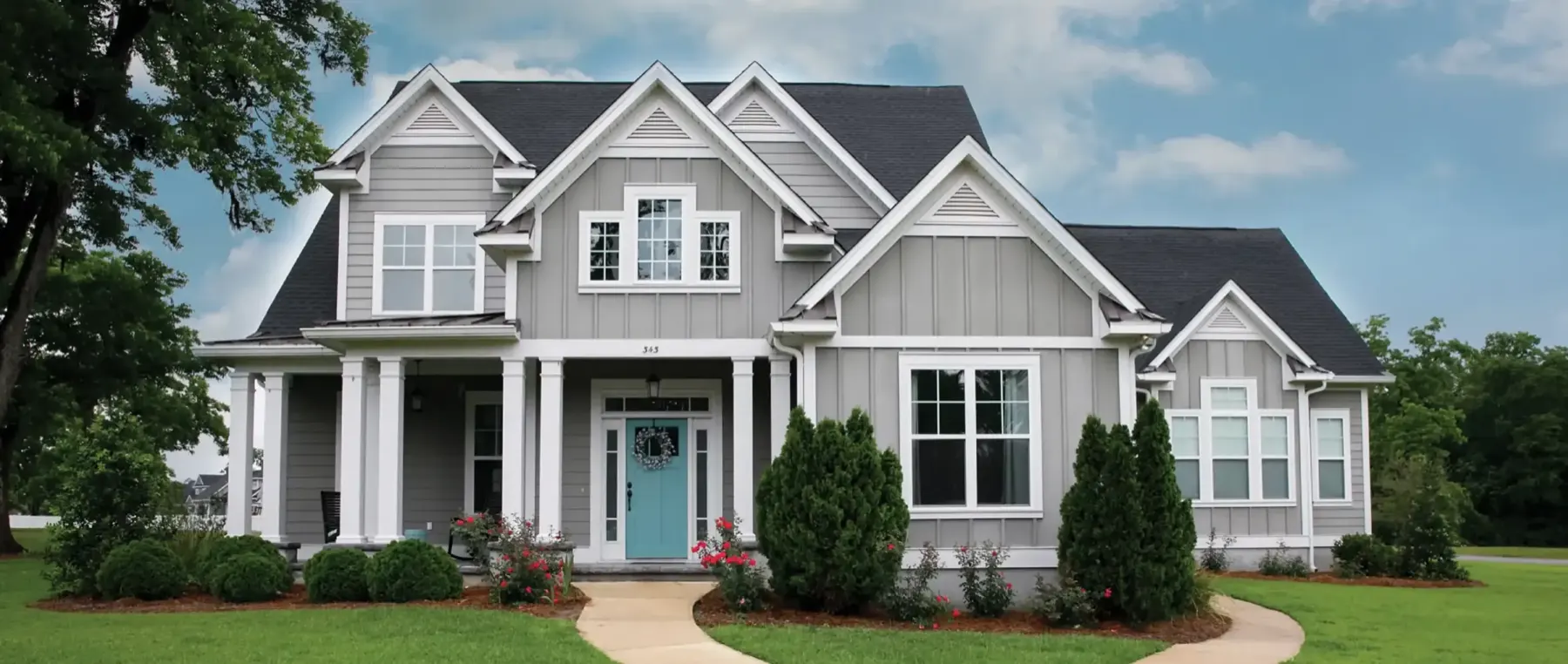 A clean grey two-story house with a white porch
